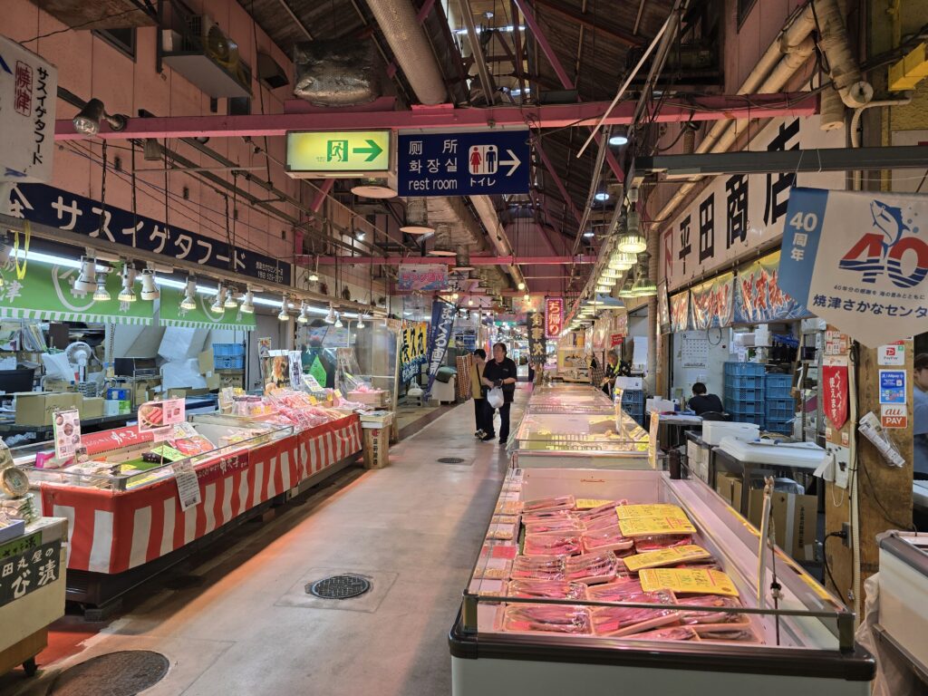 Indoor aisle of Yaizu Fish Market lined with seafood stalls and displays of fresh tuna and fish