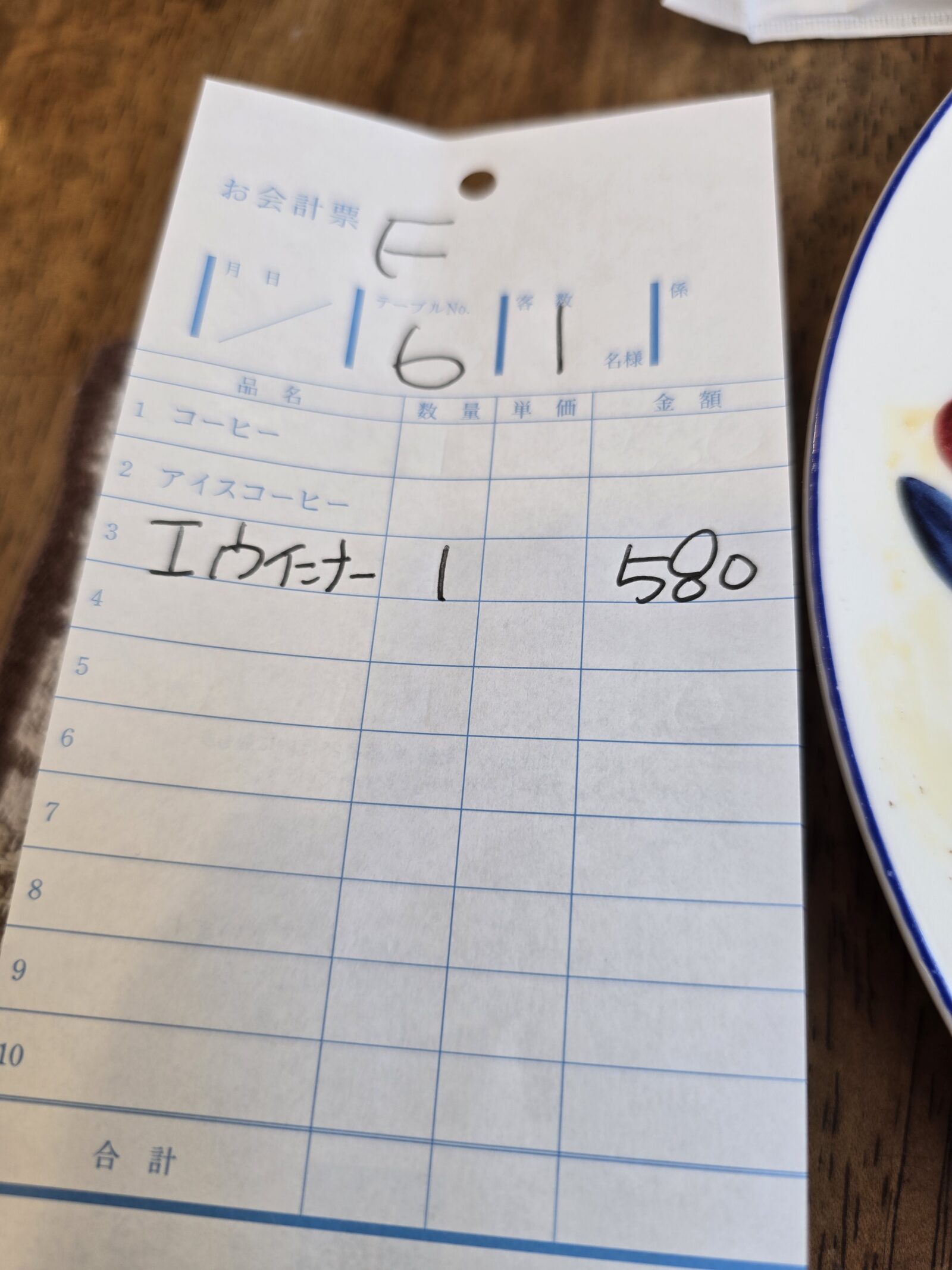 A handwritten café receipt in Japan, showing the affordable price of a morning set meal at just 580 yen.