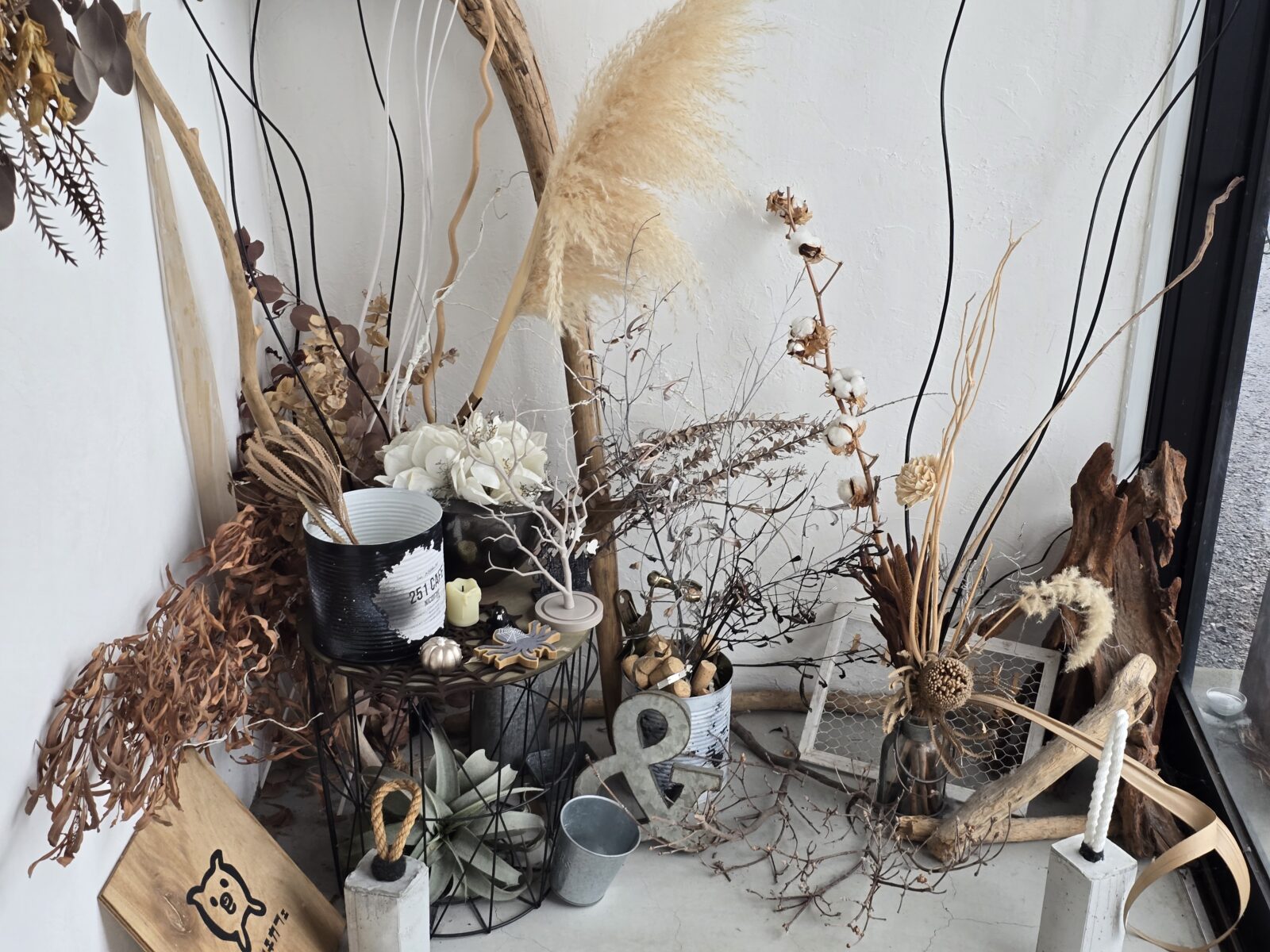 A corner inside 251 Café decorated with dried flowers, pampas grass, driftwood, and simple natural elements, giving a calm and cozy aesthetic.
