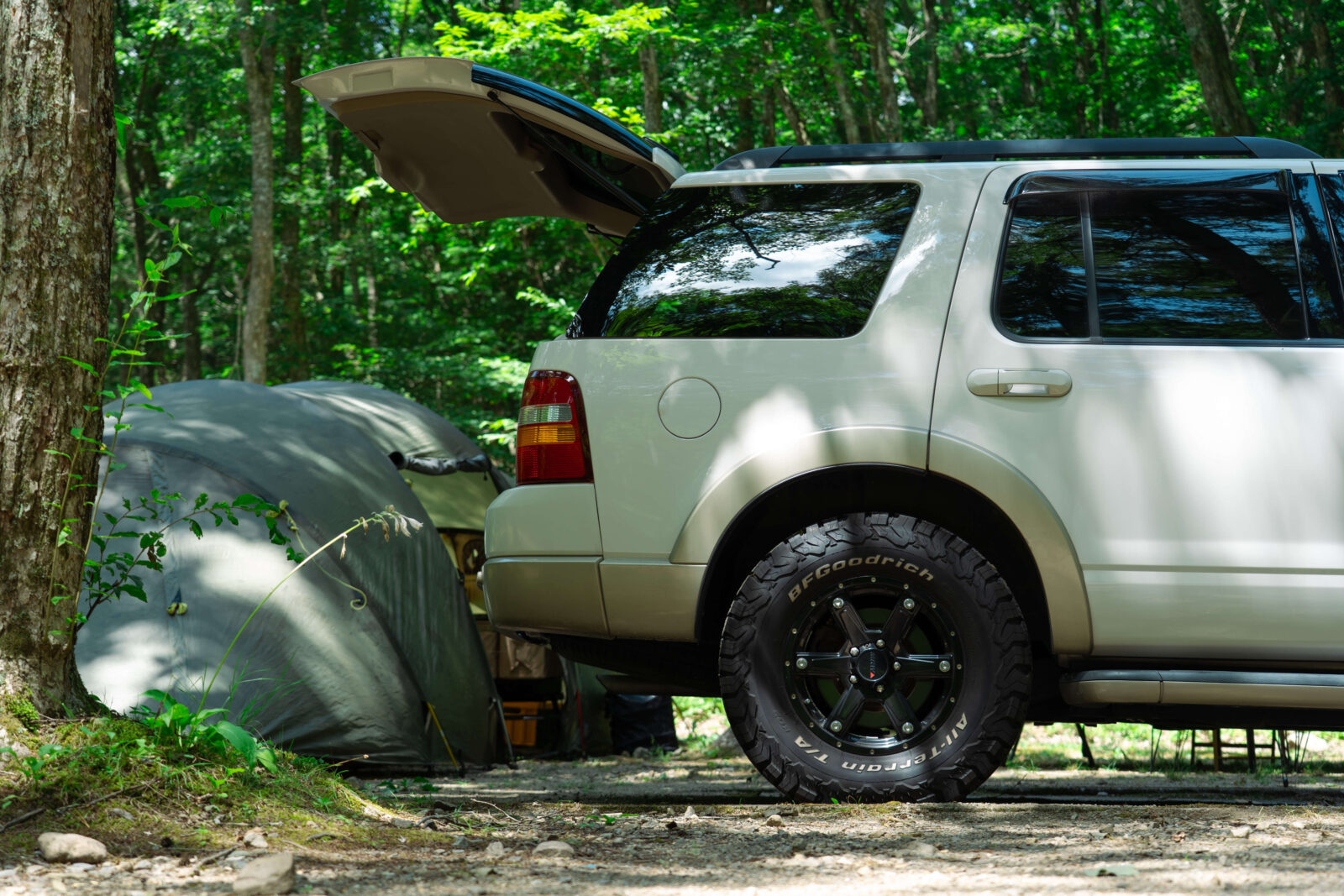 Family car and tent set up under tall trees at Pascal Kiyomi Auto Campsite in Gifu, Japan.