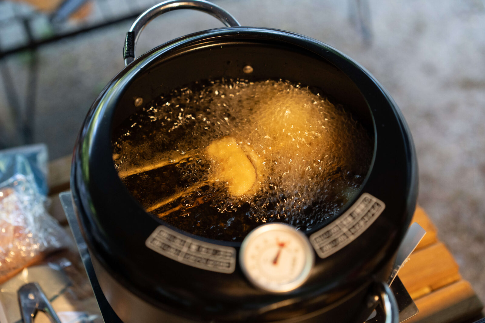 Japanese kushikatsu skewers frying in hot oil during outdoor camping in Gifu.