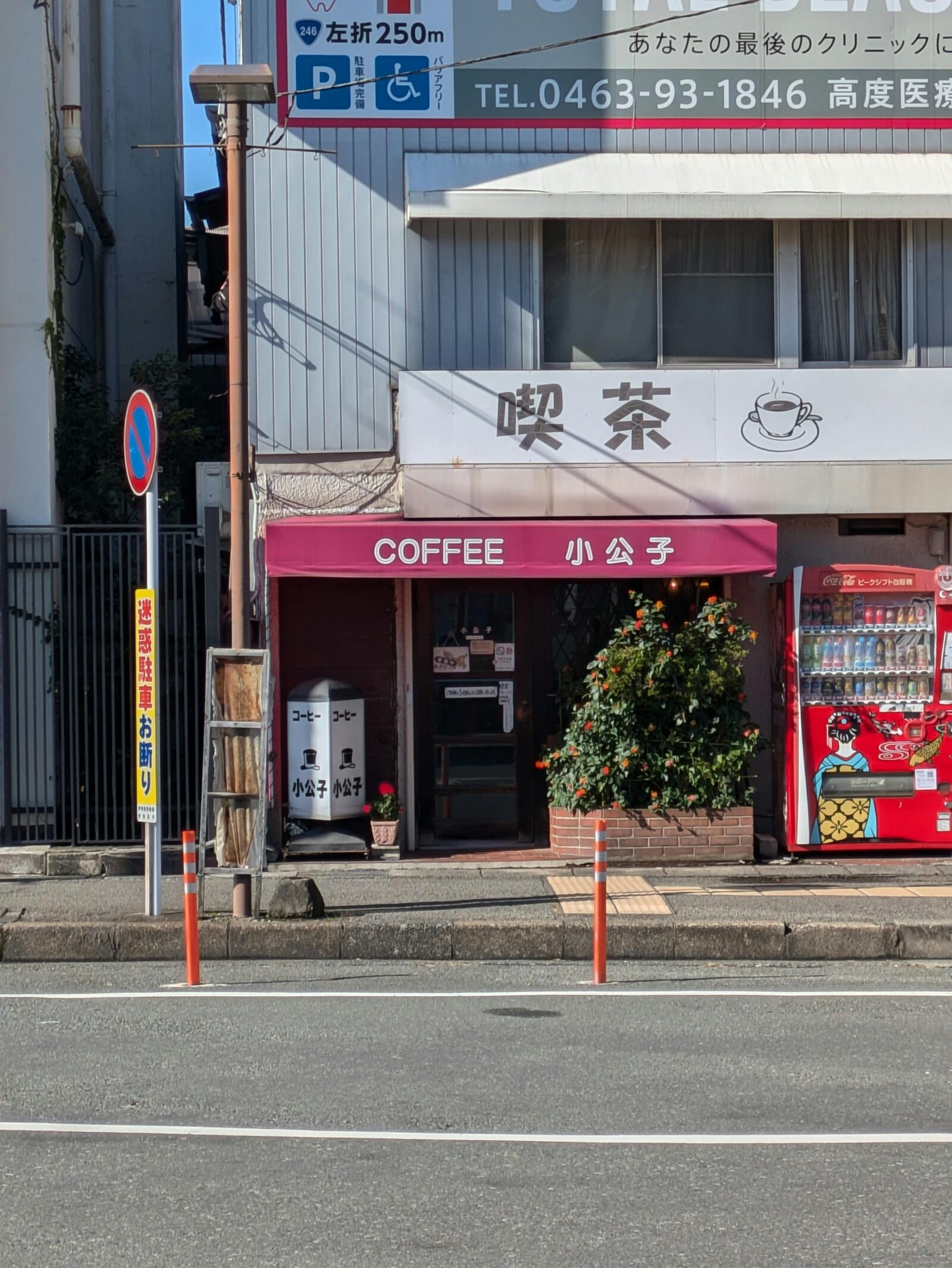 The exterior of a retro kissaten café in Japan with a pink awning and sign “Coffee 小公子,” a cozy local spot for morning sets.