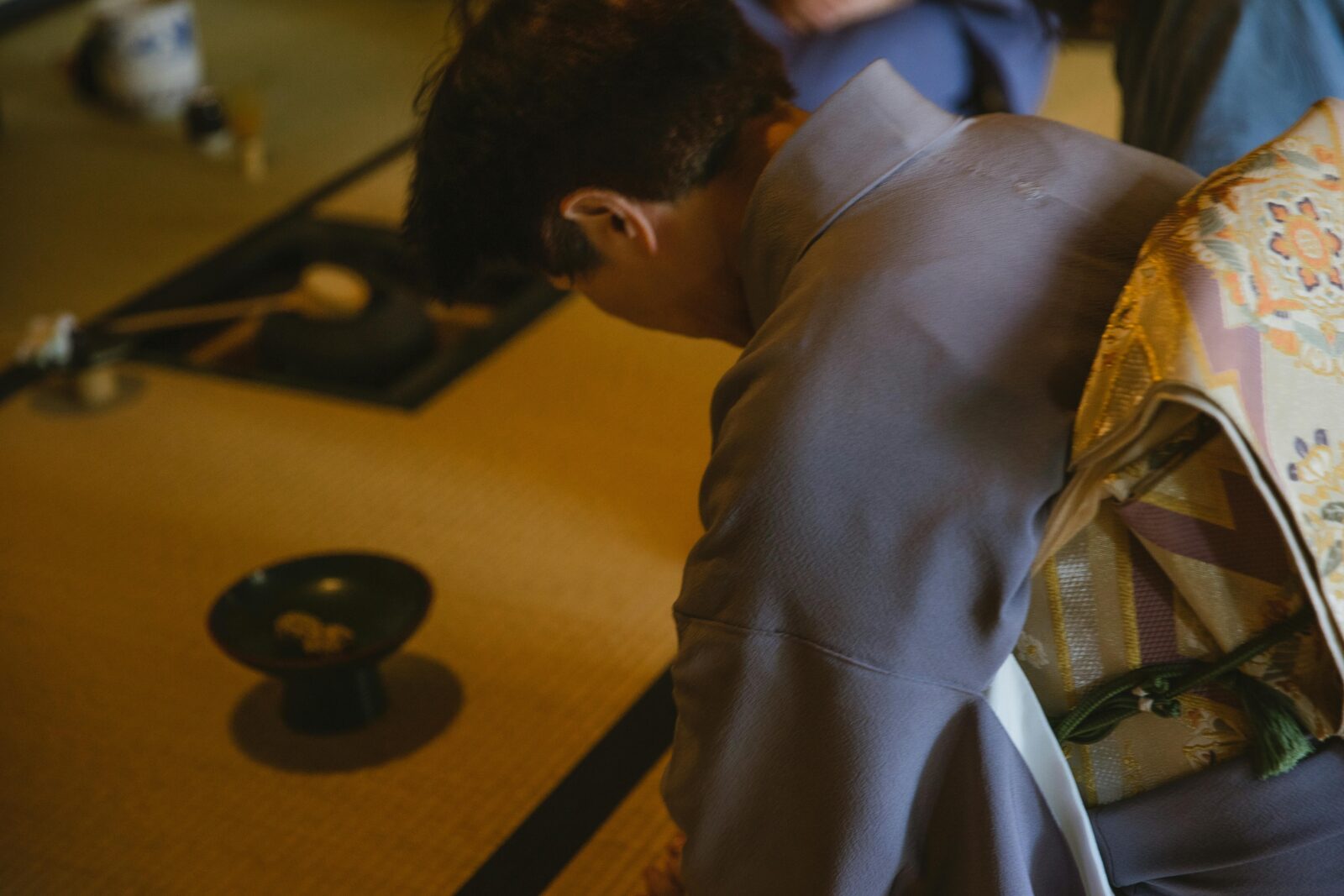 A lady in kimono bowing in like tea ceremony